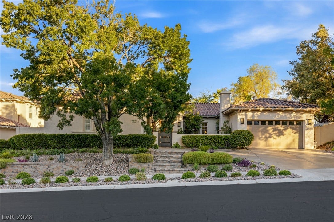 Manicured landscaping and stone accents frame this classic tile-roof exterior.