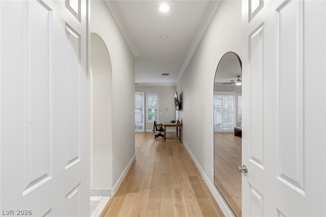 Crown molding and hardwood flooring guide the eye through this welcoming central hallway.