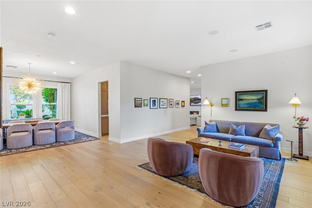 Warm hardwood flooring flows throughout this open layout, seamlessly connecting living and dining areas.