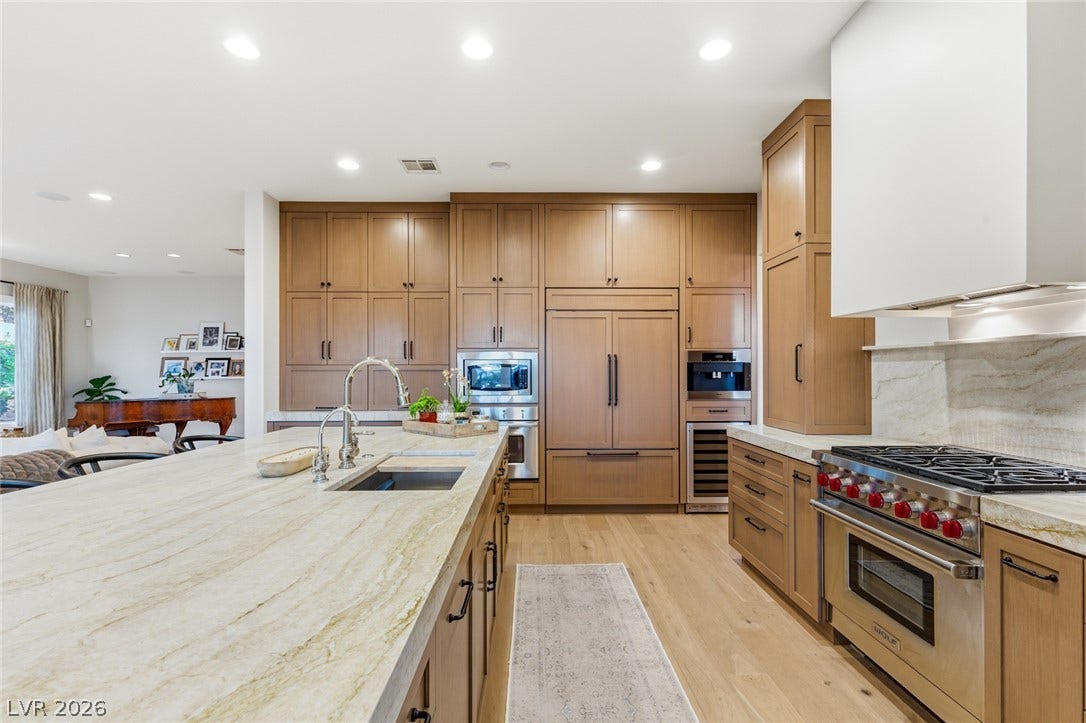 Rich wood cabinetry and expansive stone countertops define this well-appointed gourmet kitchen space.