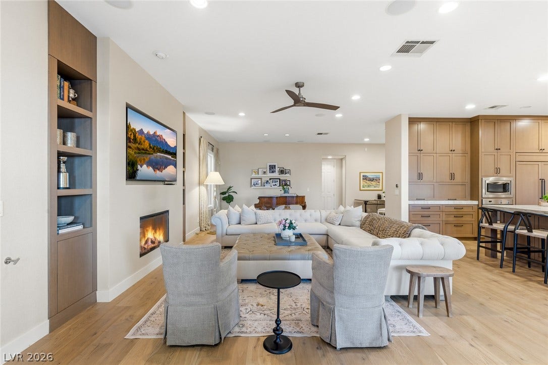 Warm wood flooring, custom built-ins, and a modern inset fireplace define this inviting living space.