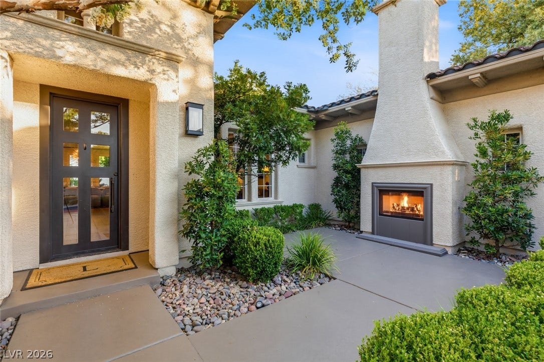 An inviting exterior hearth warms this elegant stucco entry courtyard.