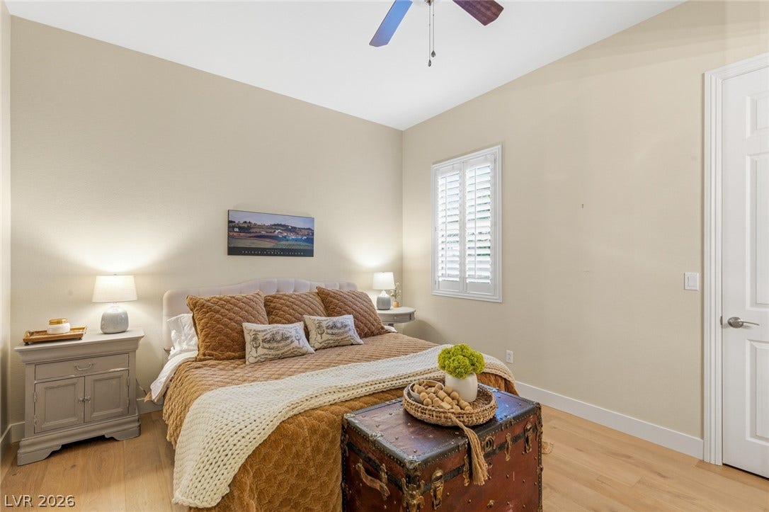 High ceilings and warm wood floors define this tranquil sleeping space with plantation shutters.