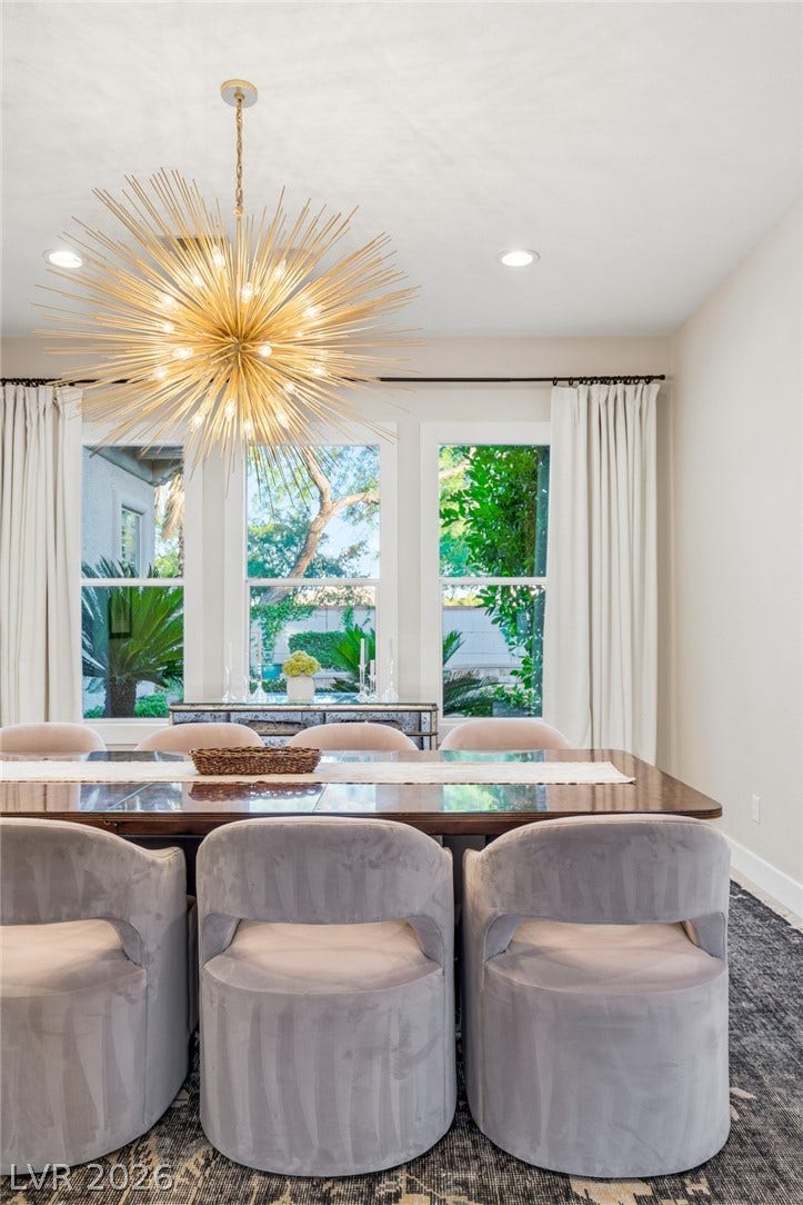 Sunlight streams through large windows highlighting the detailed molding and high ceilings.