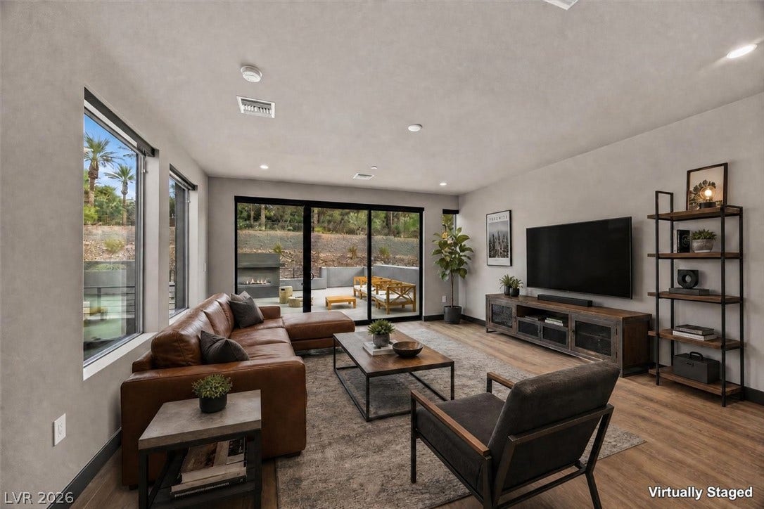Sliding glass doors connect the spacious main living area to a private back patio.