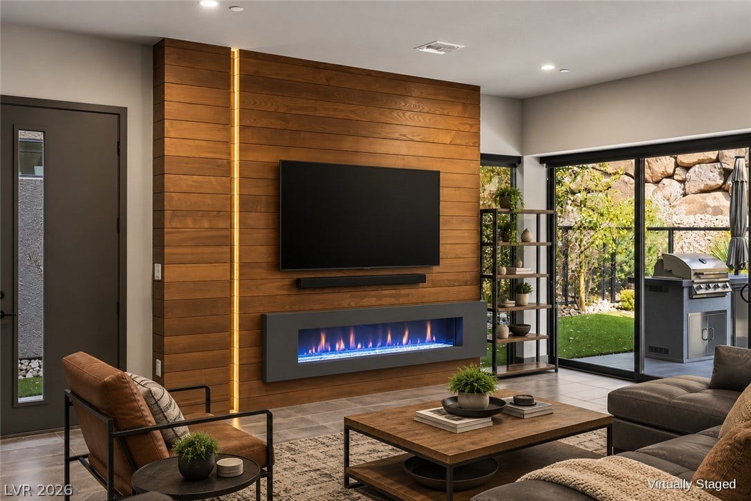 Warm wood paneling frames a linear gas fireplace alongside sliding glass doors to the patio.