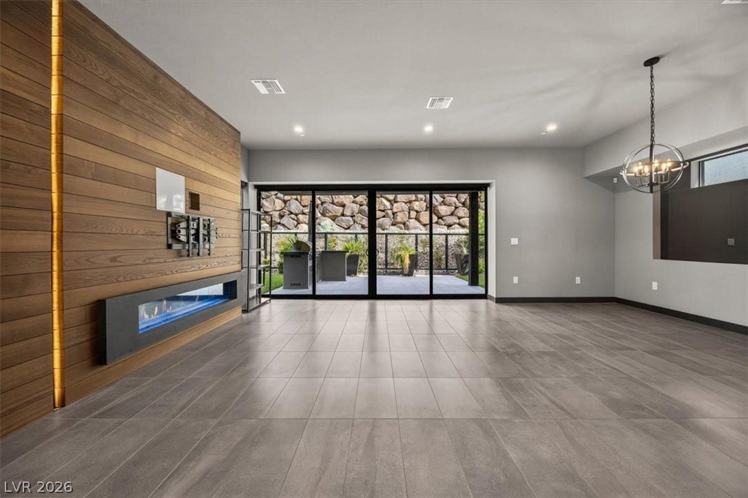 Polished tile flooring and a sleek linear fireplace anchor this modern living space.