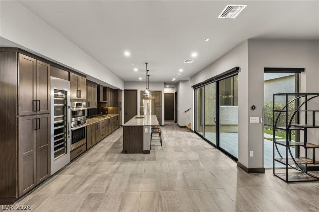 Sleek modern cabinetry and glass sliding doors define this airy open-concept space.