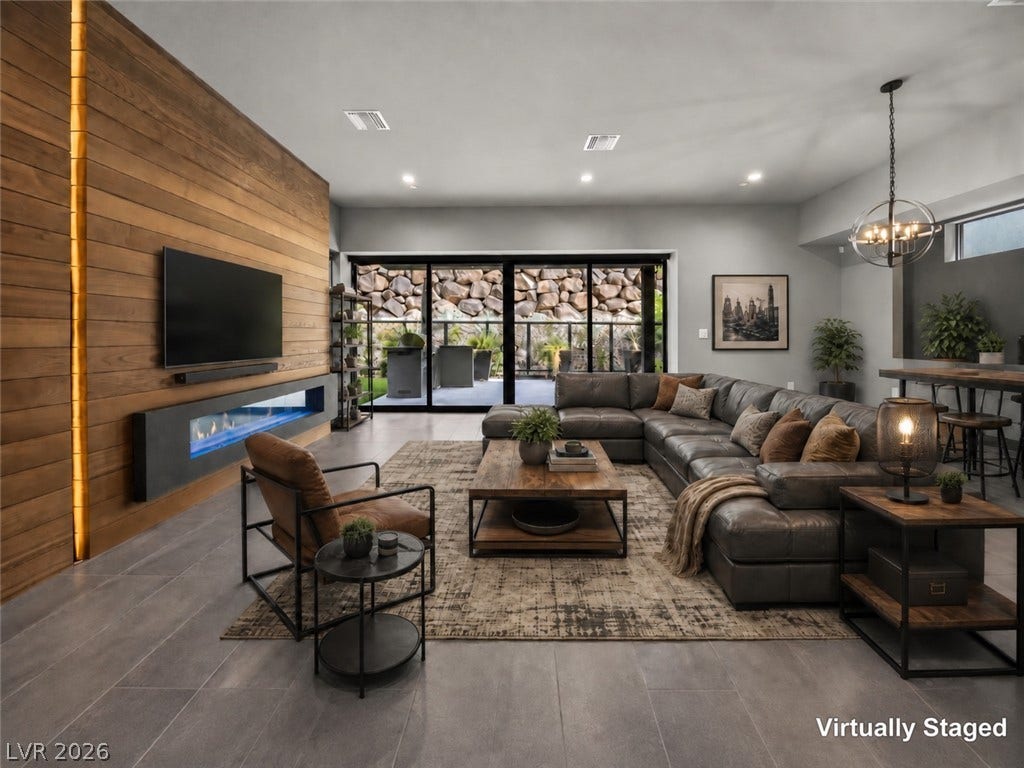 An integrated fireplace accents the wood-paneled wall alongside sliding glass doors to the patio.