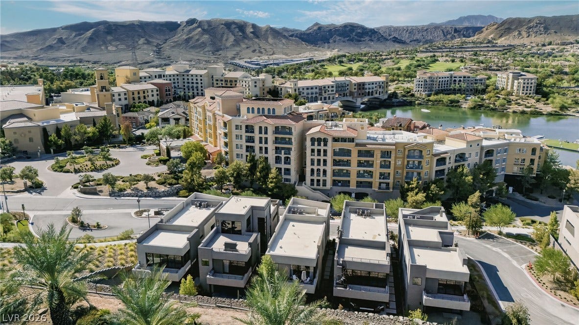 Dramatic mountain peaks and a serene lake frame this expansive resort-style community landscape.