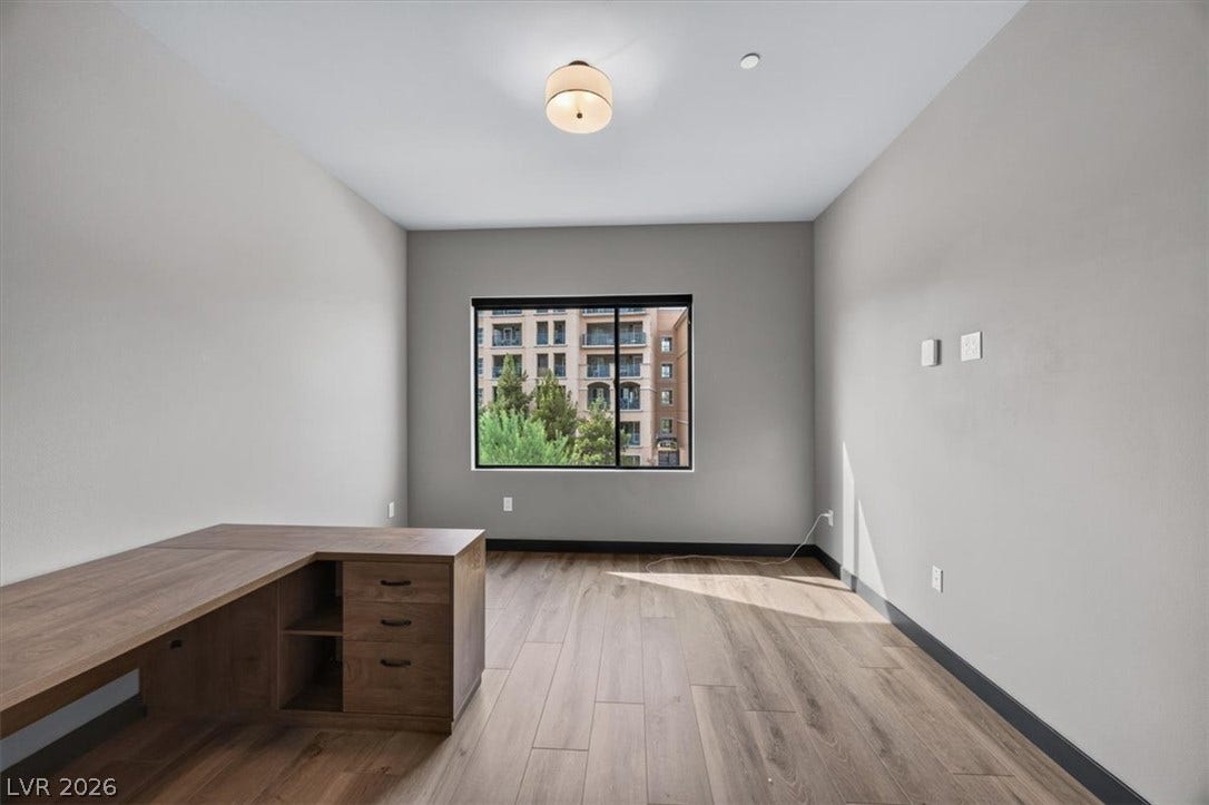 Smooth wood-style flooring and high ceilings define this versatile, windowed workspace.