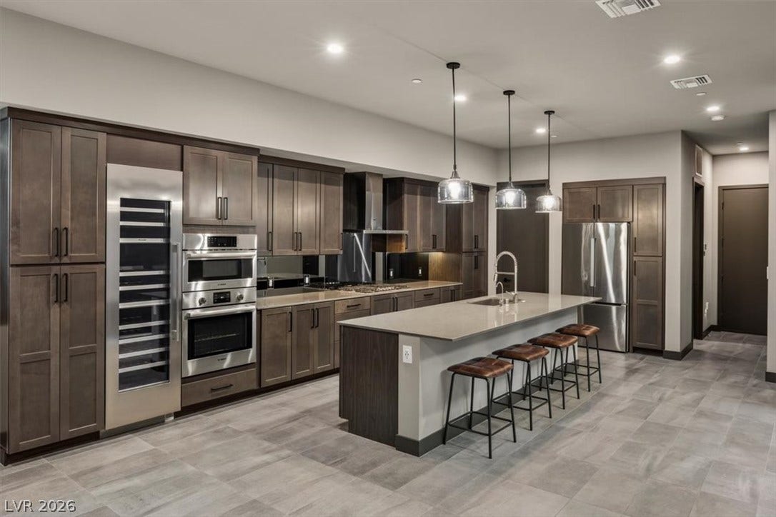 Gleaming stone countertops and rich wooden cabinetry anchor this contemporary gourmet workspace.