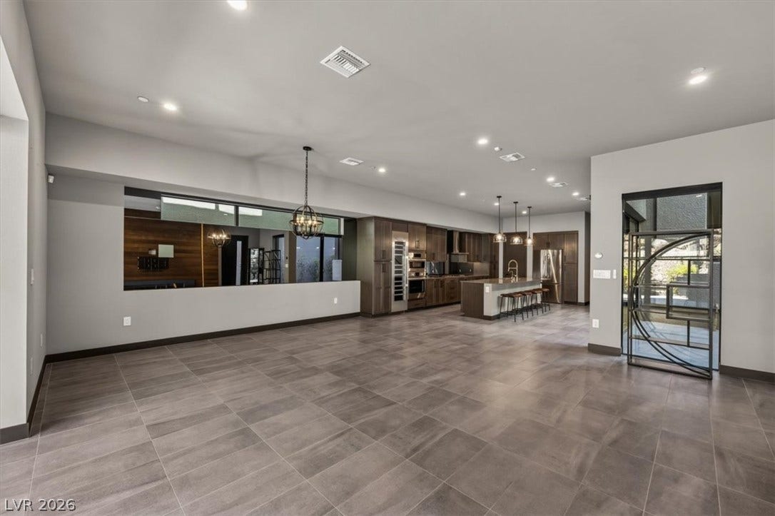 Clean tile flooring and smooth drywall define this expansive modern open-concept interior.