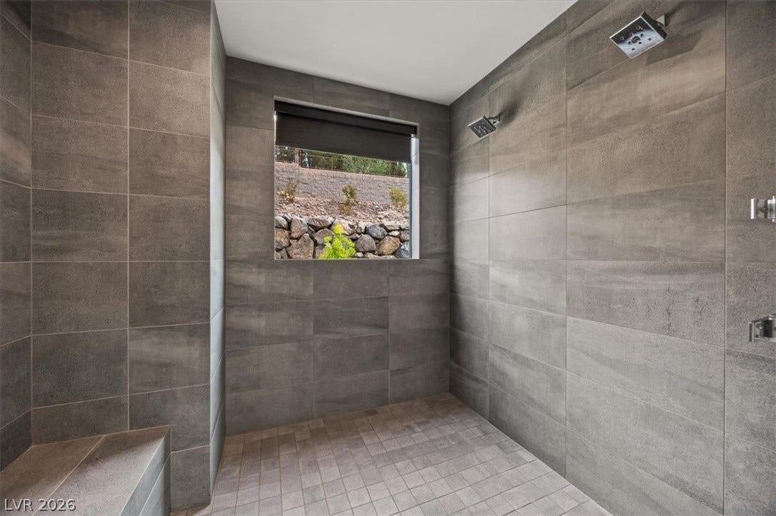 Dramatic large-format tiling wraps this luxurious walk-in shower complete with dual showerheads.