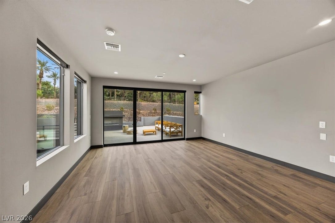 Sliding glass doors open from this versatile living area to a private outdoor patio.