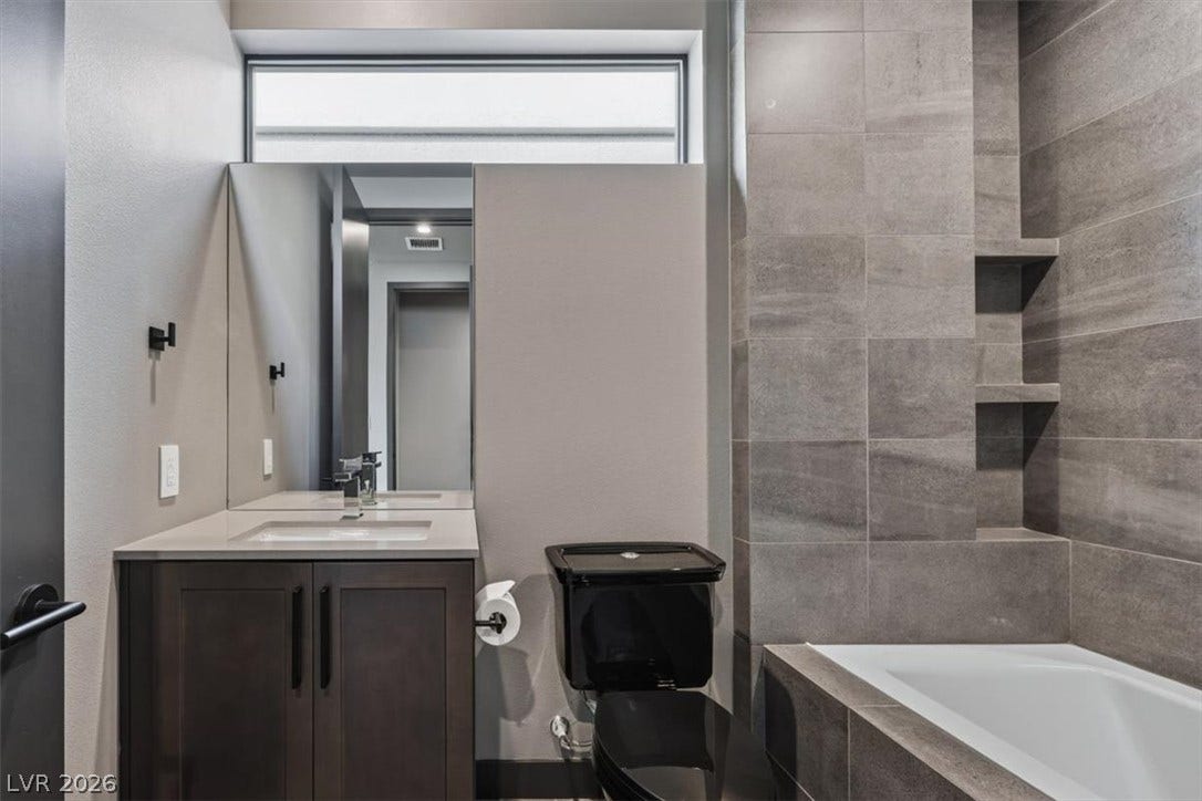 A deep soaking tub sits nestled beside tiled walls in a modern bathroom design.