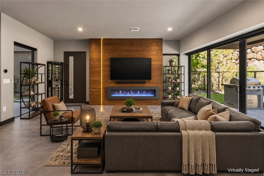 An open floor plan integrates seamless indoor-outdoor living through massive sliding glass doors.