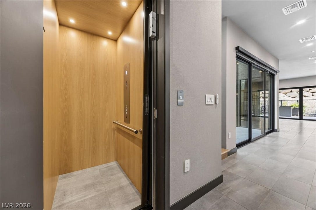 Sleek contemporary design integrates a wood-lined private elevator with durable tile flooring.
