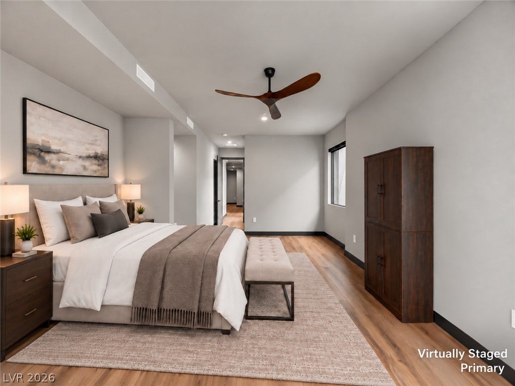 Rich hardwood flooring sweeps across a serene bedroom retreat with recessed lighting.