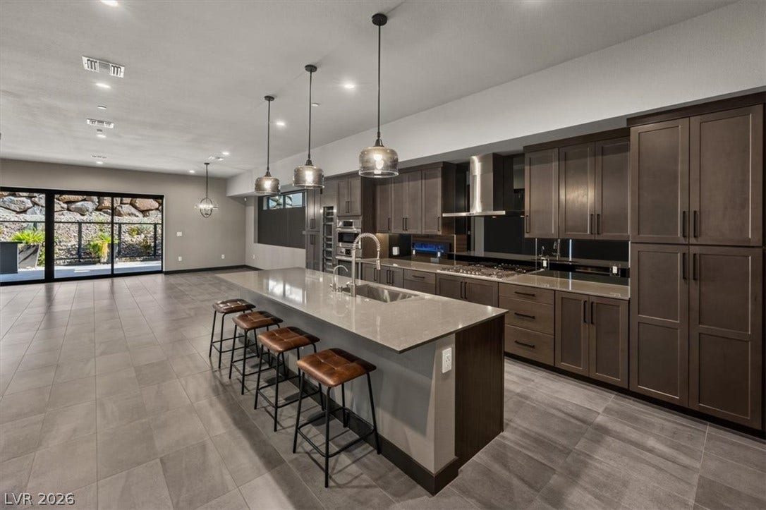 Clean lines and sleek stone surfaces define this modern, open-concept culinary space.