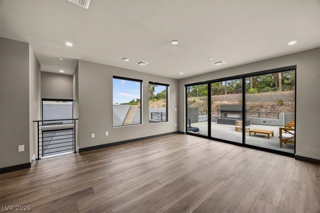 Wide sliding glass doors connect this light-filled room directly to the outdoor patio.