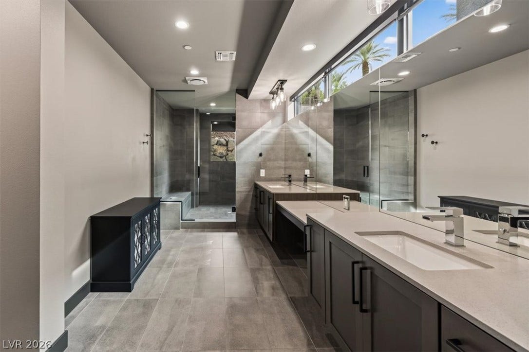 Clean lines and stone tile floors define this modern bathroom with a glass-enclosed shower.