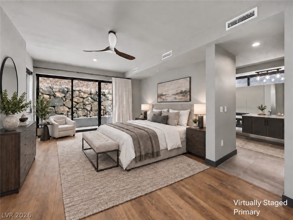 Rich wood floors and massive glass doors accent this quiet, modern bedroom suite.