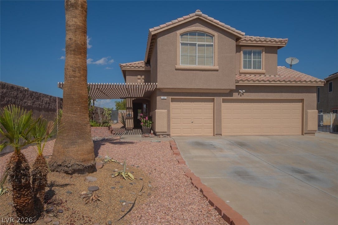 121 Heather Drive, Henderson, NV 89002 Desert landscaping and a concrete driveway lead to a classic stucco exterior with tile roofing.