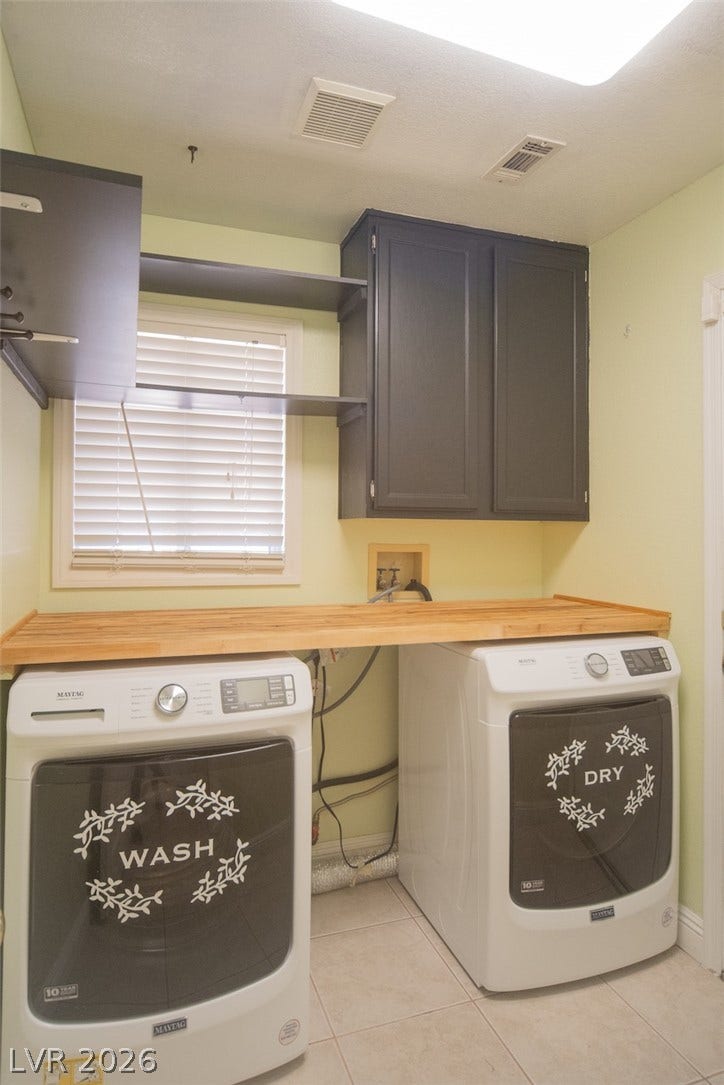 121 Heather Drive, Henderson, NV 89002 Functional workspace highlights this dedicated laundry zone featuring overhead cabinetry and a built-in folding counter.
