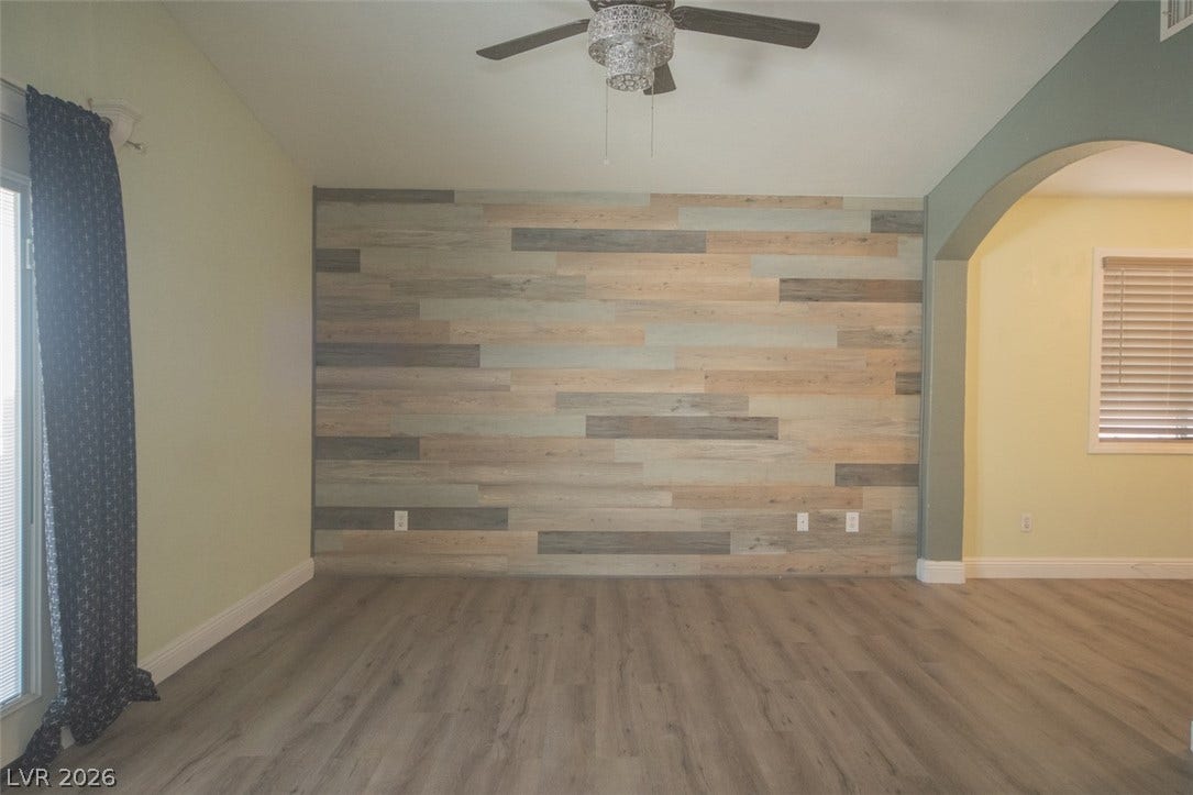 121 Heather Drive, Henderson, NV 89002 Smooth wood-look flooring and an arched opening define this versatile living area.