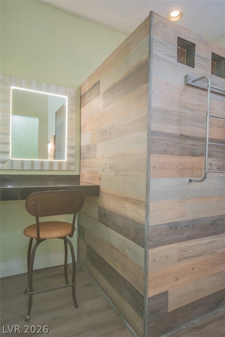 121 Heather Drive, Henderson, NV 89002 Textured wood-look walls pair with a floating vanity and integrated lighting in this modern bathroom.