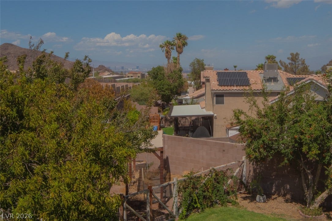 121 Heather Drive, Henderson, NV 89002 Distant skyline vistas frame this desert hillside property surrounded by lush green foliage.