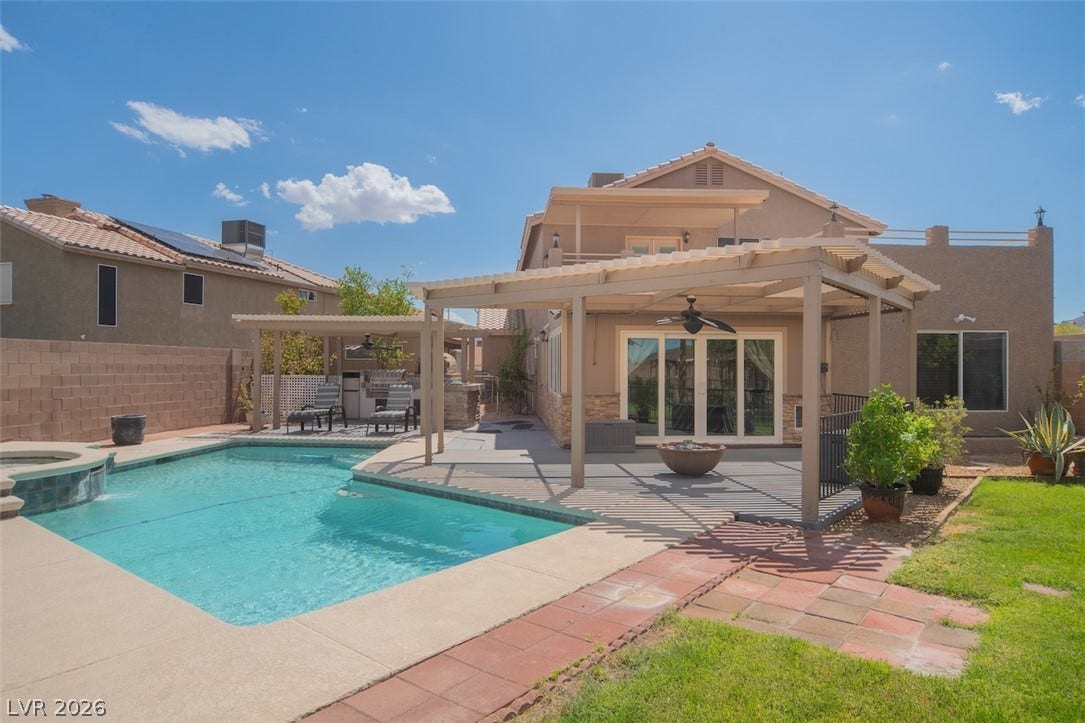 121 Heather Drive, Henderson, NV 89002 An inviting backyard oasis features a sparkling swimming pool, shaded patios, and neat green lawns.