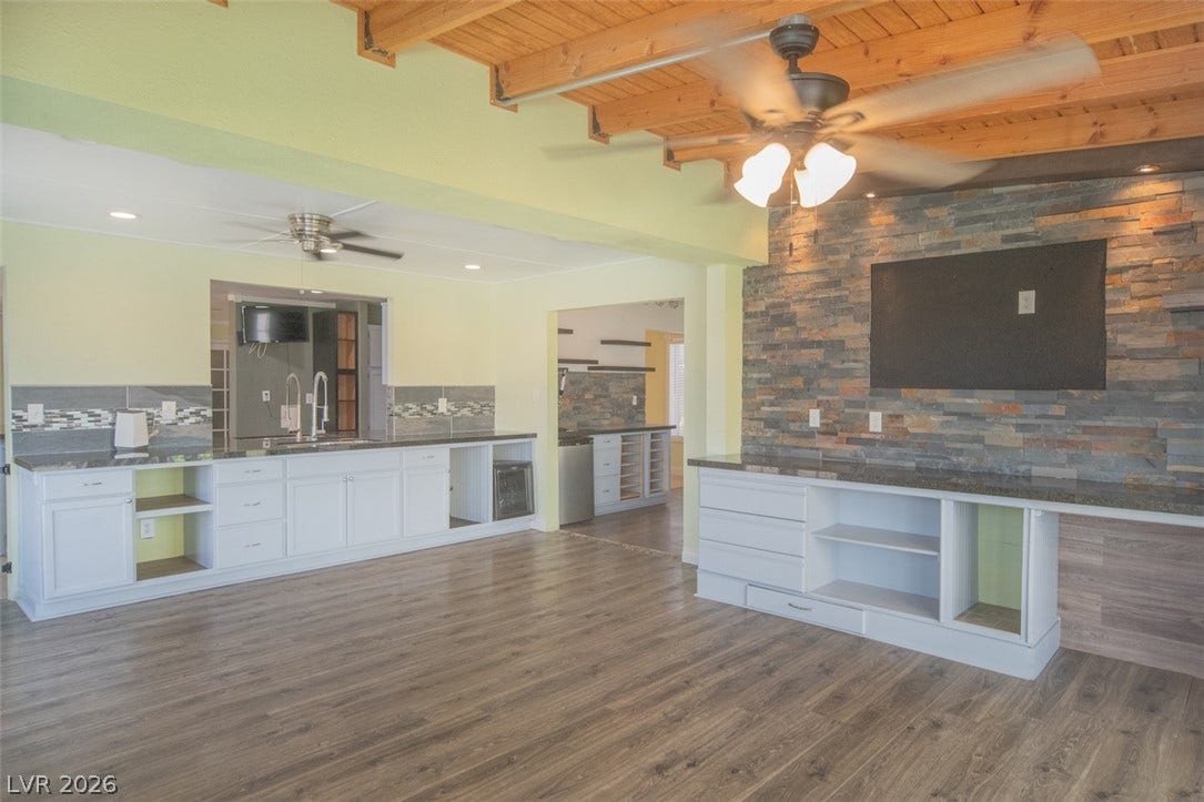 121 Heather Drive, Henderson, NV 89002 Exposed wood beams and a rustic stone wall define this open concept living area.