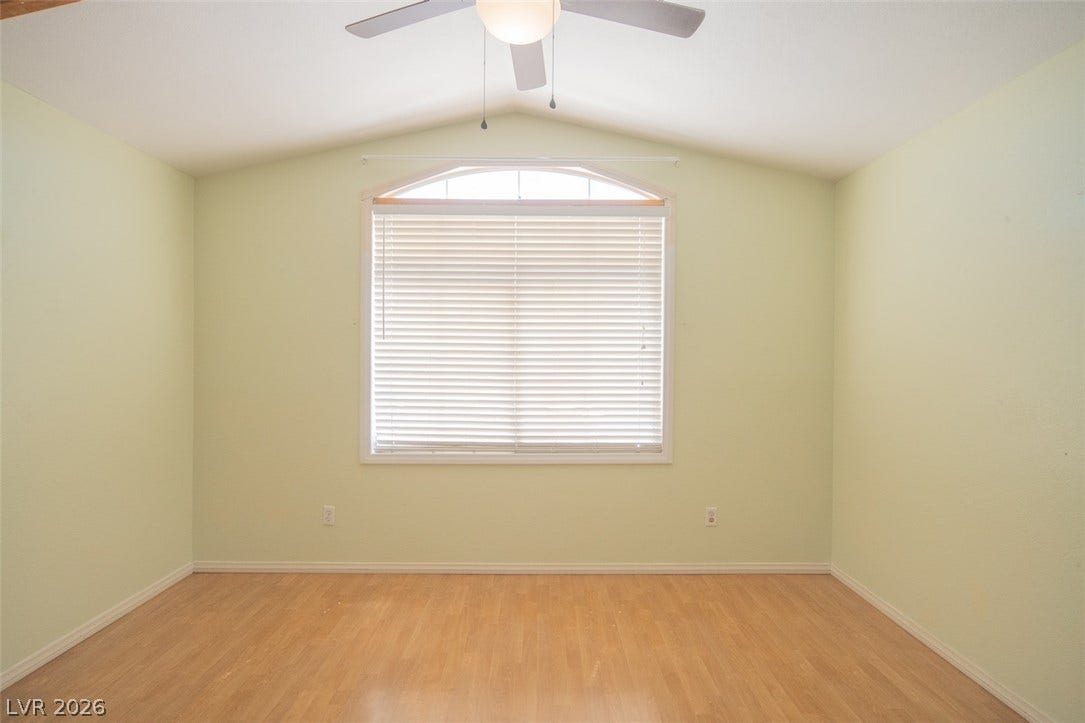 121 Heather Drive, Henderson, NV 89002 Vaulted ceilings and warm wood floors anchor this versatile secondary bedroom space.