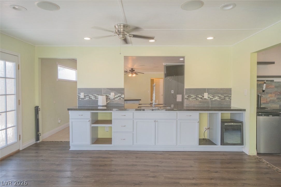 121 Heather Drive, Henderson, NV 89002 Gleaming wood-look floors anchor a functional kitchen wet bar beneath clean recessed lighting.