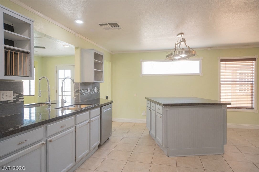 121 Heather Drive, Henderson, NV 89002 Ample counter space and a central island highlight this tiled kitchen workspace.
