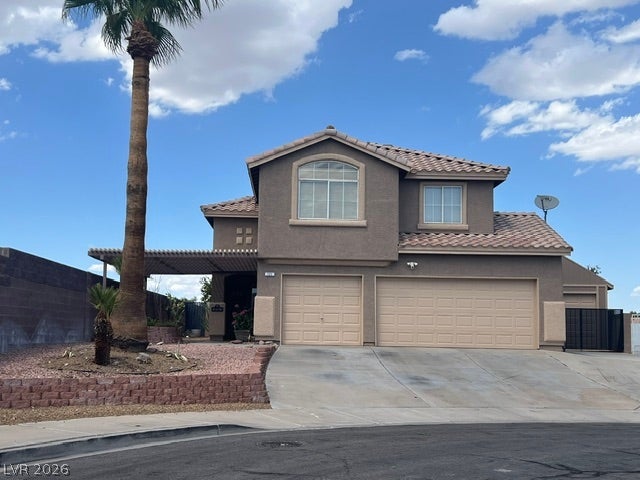 121 Heather Drive, Henderson, NV 89002 Two-story home features a classic stucco exterior and tiled roofline under desert skies.