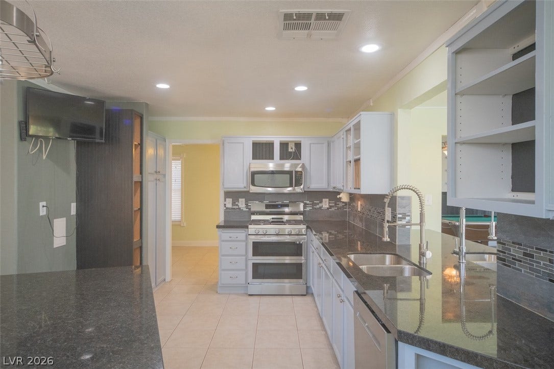121 Heather Drive, Henderson, NV 89002 Polished granite countertops and classic tile flooring anchor this functional, well-appointed culinary space.