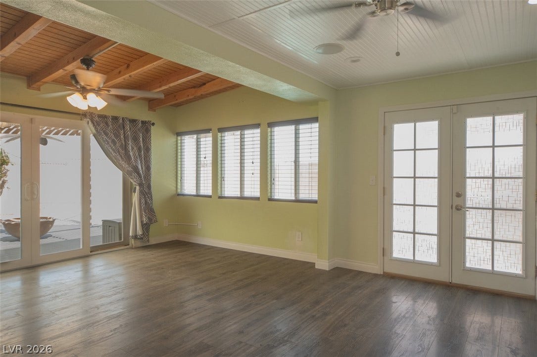 121 Heather Drive, Henderson, NV 89002 Exposed wood beams and durable plank flooring enrich this versatile garden-facing room.