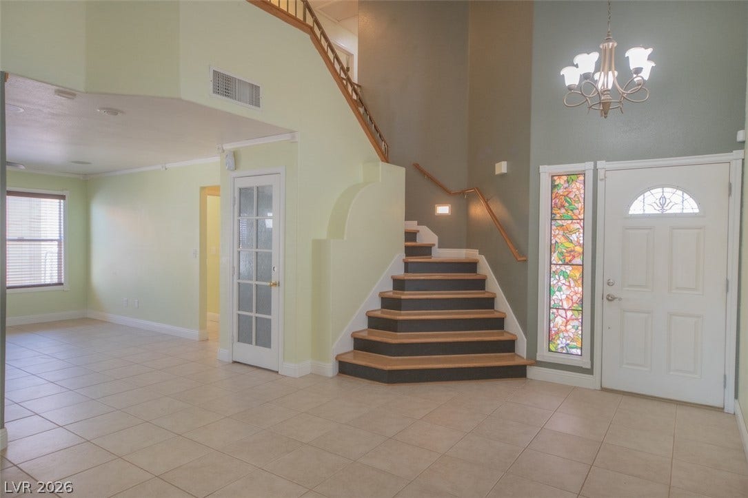 121 Heather Drive, Henderson, NV 89002 An inviting entrance foyer welcomes guests with soaring ceilings, tile flooring, and a central staircase.