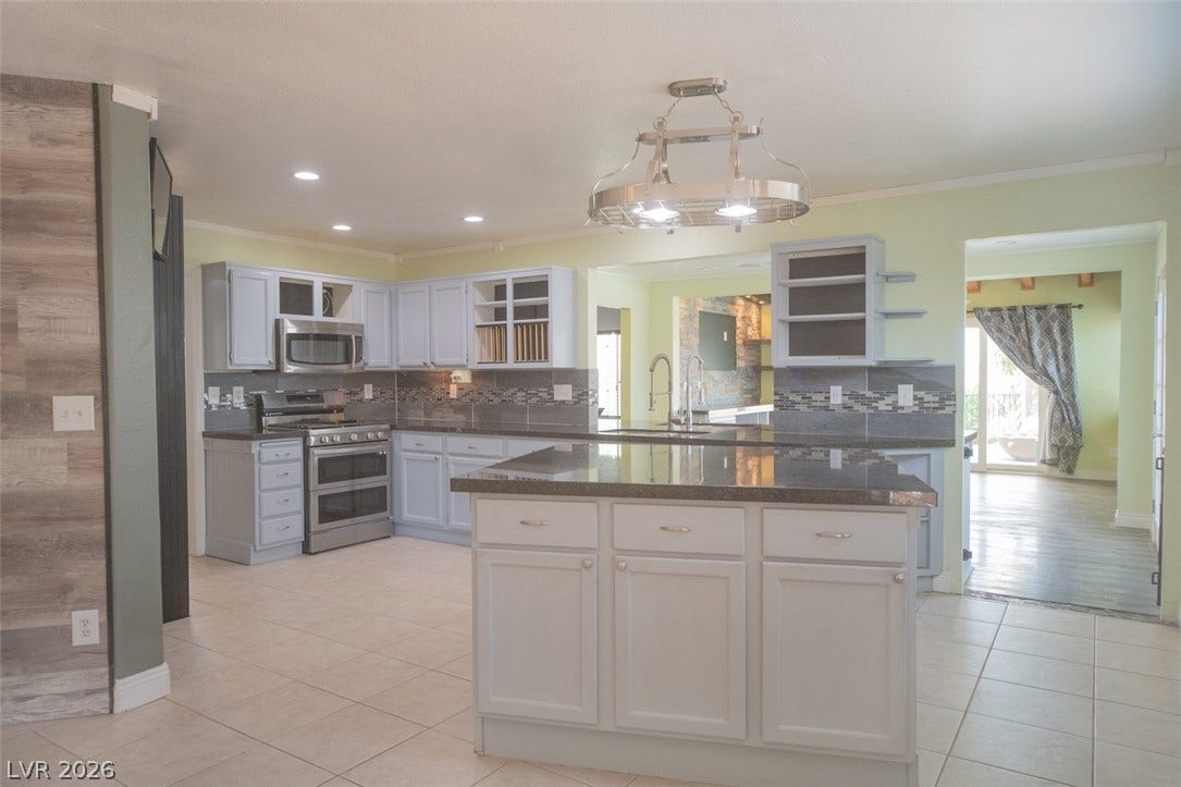121 Heather Drive, Henderson, NV 89002 Polished stone counters and matching tiled floors define this open cooking space.