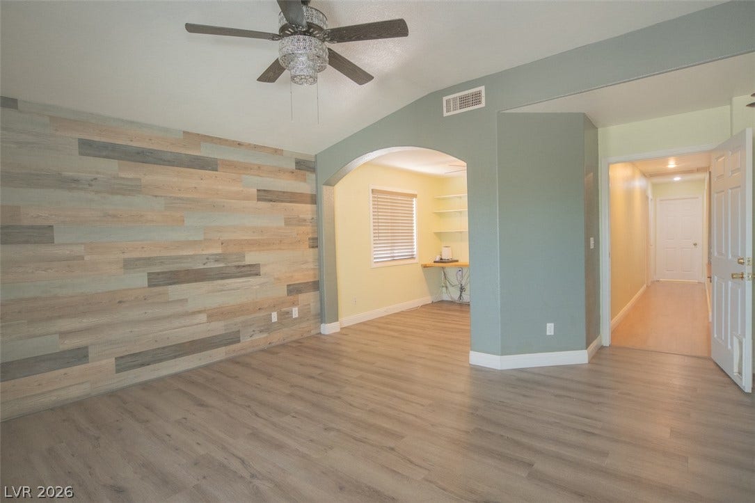 121 Heather Drive, Henderson, NV 89002 Smooth wood-look flooring and a vaulted ceiling define this versatile living area with arched entryways.