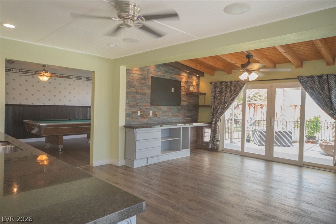 121 Heather Drive, Henderson, NV 89002 Rich wood plank flooring anchors an open layout connecting versatile living spaces and outdoor access.