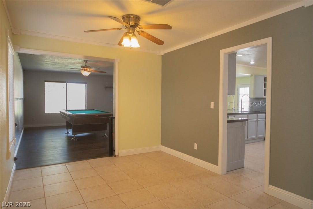 121 Heather Drive, Henderson, NV 89002 Tiled floors and crown molding define this open dining area connecting to adjacent rooms.