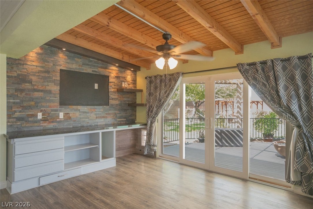 121 Heather Drive, Henderson, NV 89002 Exposed wood beams and a stone accent wall define this warm living area.