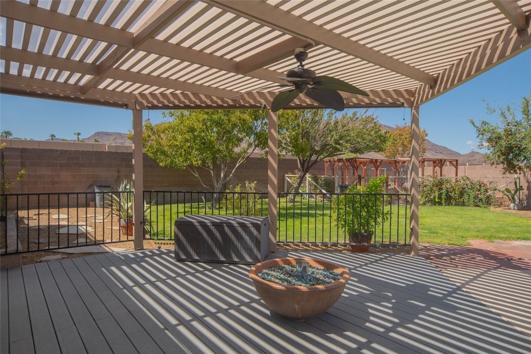 121 Heather Drive, Henderson, NV 89002 An inviting covered deck overlooks a grassy backyard with mountain views.