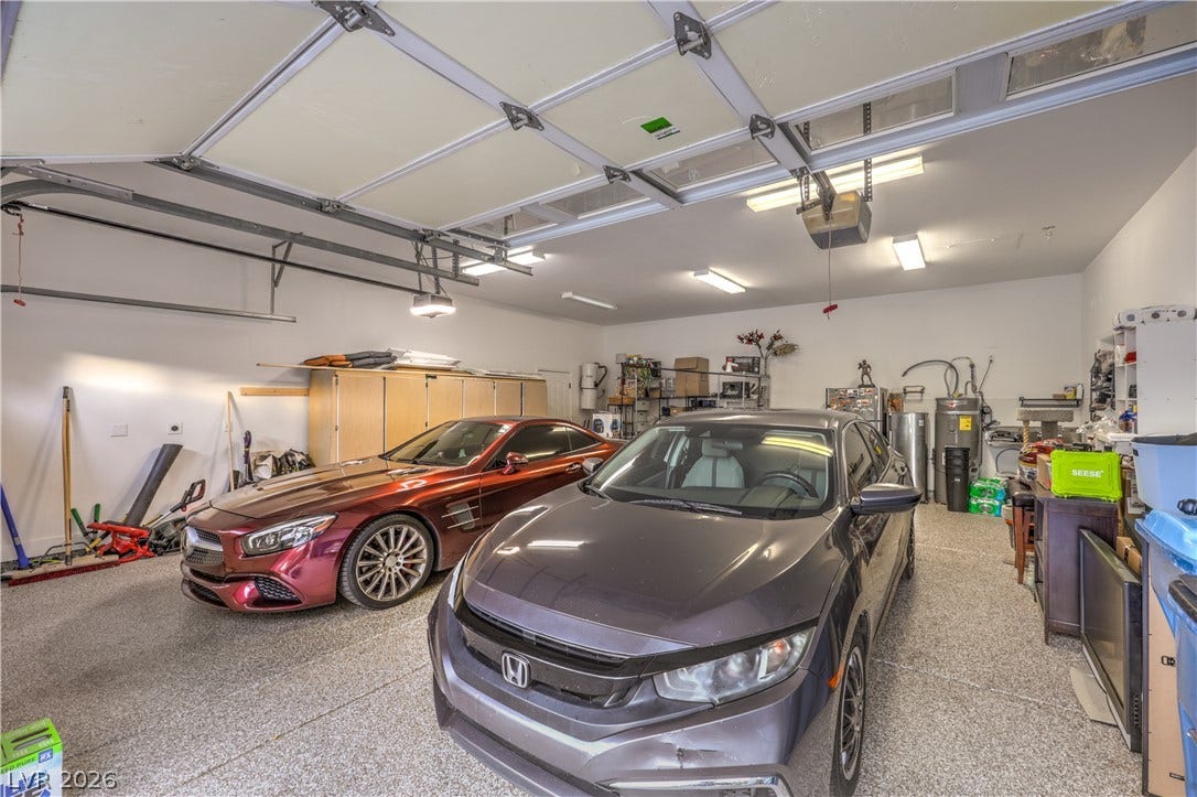 An expansive multi-vehicle garage features durable textured flooring and abundant overhead lighting.