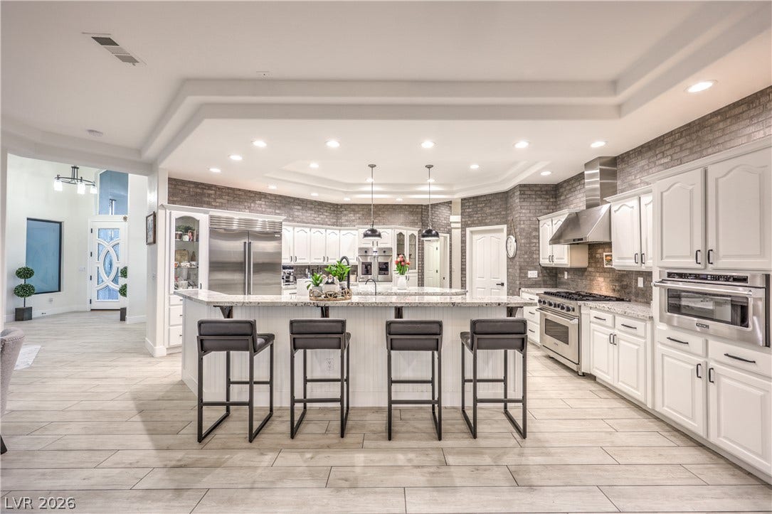 An expansive kitchen layout showcases premium stone countertops and a modern recessed ceiling design.