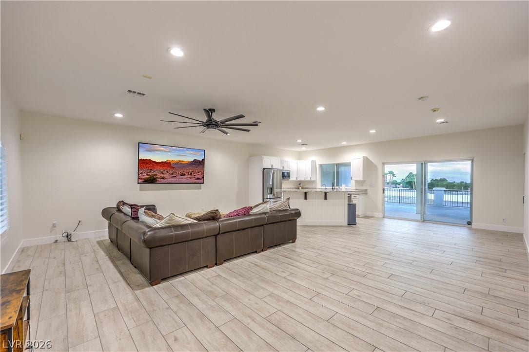 An open floorplan seamlessly connects the airy living area to a modern kitchen.